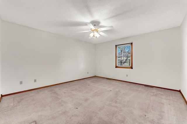 carpeted spare room featuring ceiling fan and a textured ceiling