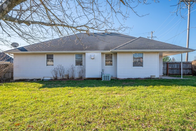 back of property with a lawn and central air condition unit