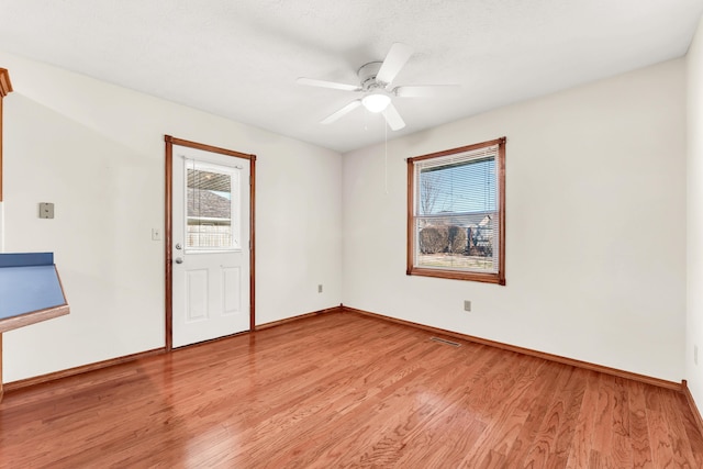 empty room with ceiling fan, light hardwood / wood-style floors, and a textured ceiling