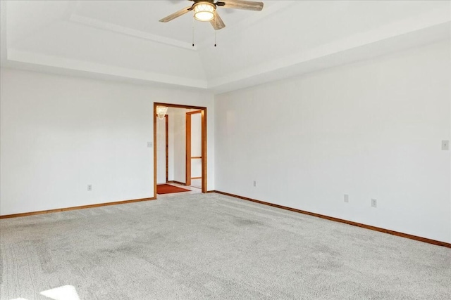 carpeted empty room featuring a raised ceiling and ceiling fan