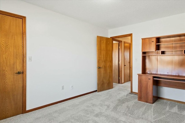 unfurnished bedroom with light colored carpet and a textured ceiling