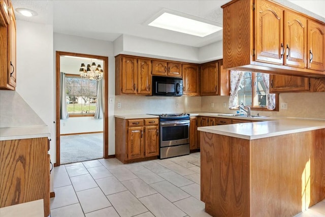 kitchen featuring sink, a notable chandelier, a healthy amount of sunlight, and stainless steel range oven