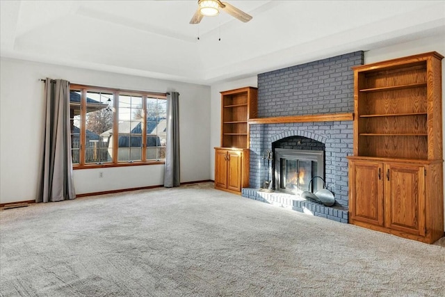 unfurnished living room with a fireplace, light colored carpet, a raised ceiling, and ceiling fan