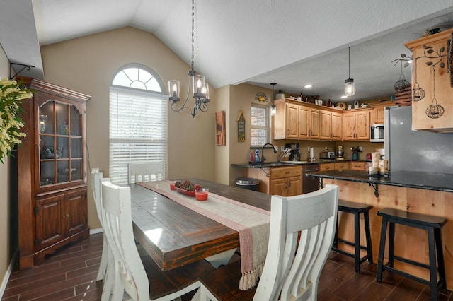 dining space featuring a textured ceiling, dark wood-type flooring, sink, a chandelier, and lofted ceiling