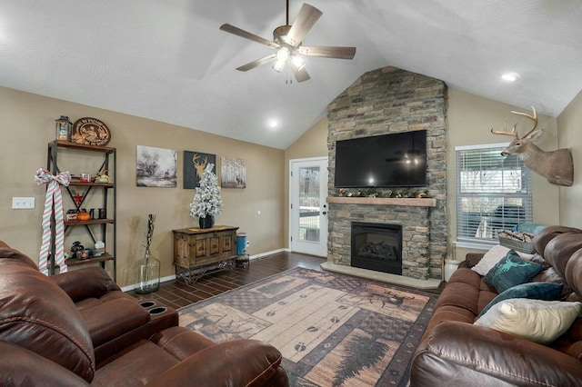 living room with a stone fireplace, plenty of natural light, lofted ceiling, and ceiling fan