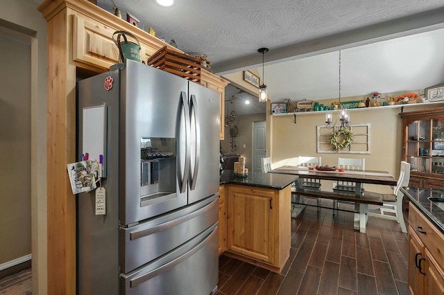 kitchen featuring stainless steel fridge, dark hardwood / wood-style flooring, a textured ceiling, decorative light fixtures, and a notable chandelier