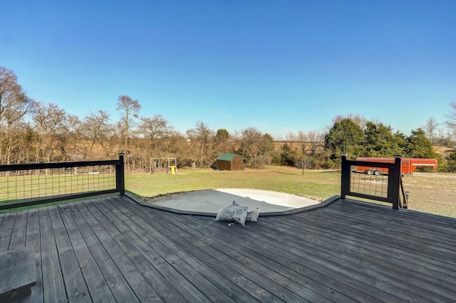 deck with a lawn and a storage shed