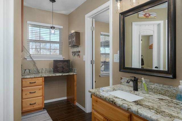 bathroom with wood-type flooring, vanity, and a healthy amount of sunlight