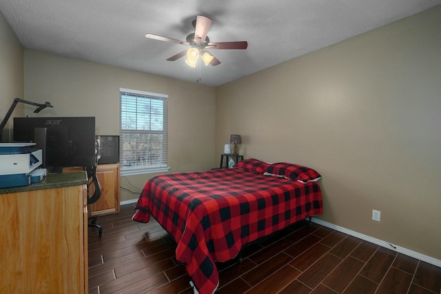 bedroom with dark hardwood / wood-style floors, ceiling fan, and a textured ceiling