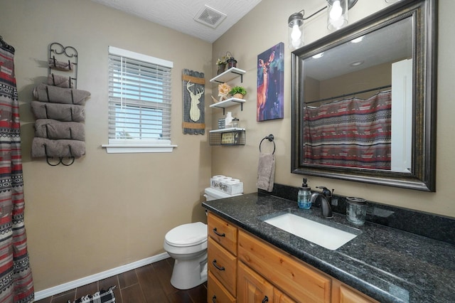 bathroom with a textured ceiling, vanity, hardwood / wood-style flooring, and toilet