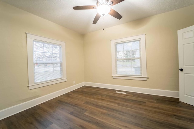 empty room with ceiling fan, dark hardwood / wood-style flooring, and a textured ceiling