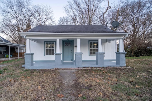 bungalow-style house with a porch and a front lawn