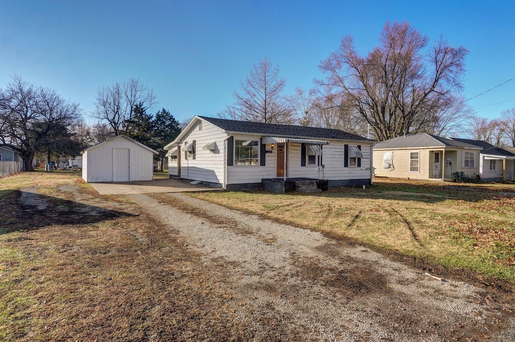 ranch-style home with a shed and a front lawn