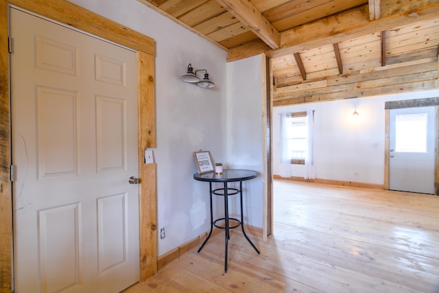 interior space featuring lofted ceiling with beams, light hardwood / wood-style flooring, and wood ceiling