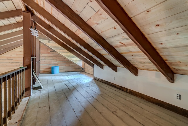 bonus room with light wood-type flooring, vaulted ceiling with beams, wooden ceiling, and wood walls