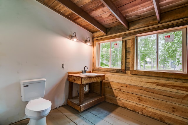 bathroom with hardwood / wood-style floors, wooden ceiling, sink, toilet, and beamed ceiling