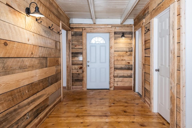 entryway with beamed ceiling, light hardwood / wood-style floors, and wooden ceiling