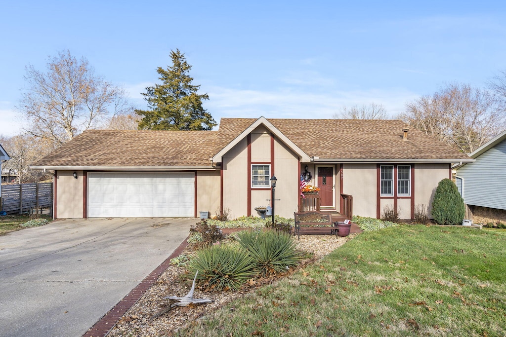 single story home with a garage and a front yard