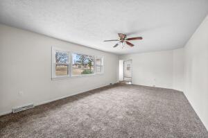 carpeted spare room with ceiling fan