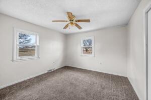 carpeted spare room with ceiling fan