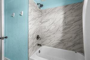 bathroom with tiled shower / bath combo