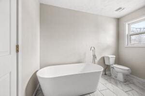 bathroom featuring a bathing tub and toilet