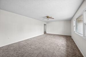 carpeted empty room featuring ceiling fan