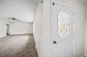 carpeted entrance foyer with ceiling fan