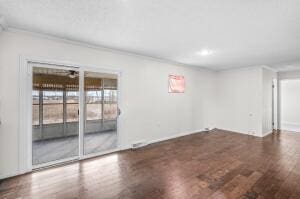 spare room with crown molding and dark wood-type flooring