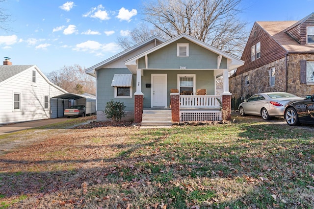 view of front of house featuring covered porch, a front lawn, and a carport