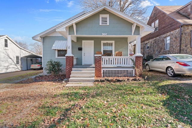 view of front facade featuring covered porch, a carport, and a front lawn