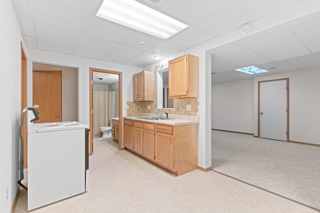 kitchen featuring a drop ceiling, light brown cabinets, backsplash, sink, and range