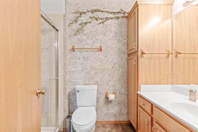 bathroom with vanity, toilet, and a shower with door