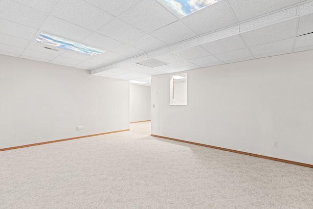 basement featuring a paneled ceiling and carpet floors