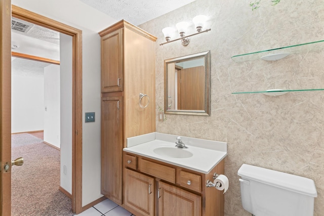 bathroom featuring vanity, toilet, and a textured ceiling