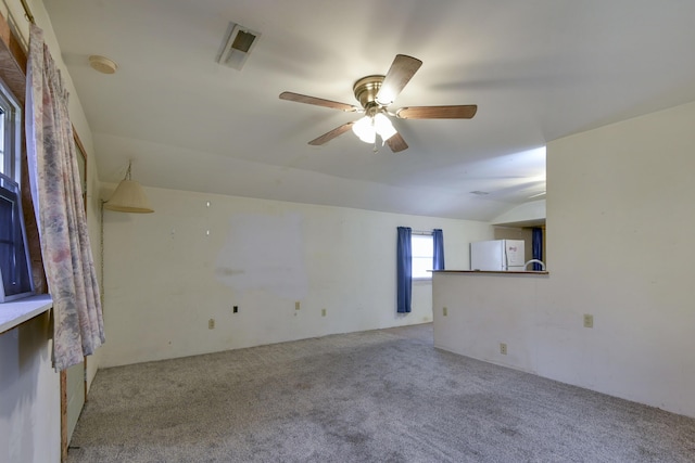 spare room with light carpet, ceiling fan, and vaulted ceiling