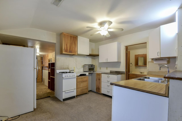 kitchen with lofted ceiling, white appliances, light carpet, sink, and white cabinetry