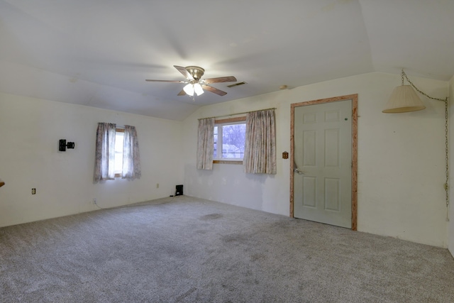 carpeted spare room featuring ceiling fan and lofted ceiling