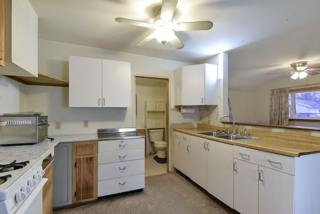 kitchen featuring light carpet, sink, ceiling fan, white range oven, and white cabinetry