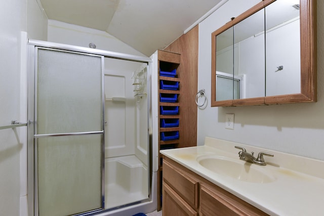 bathroom with vanity, a shower with shower door, and lofted ceiling