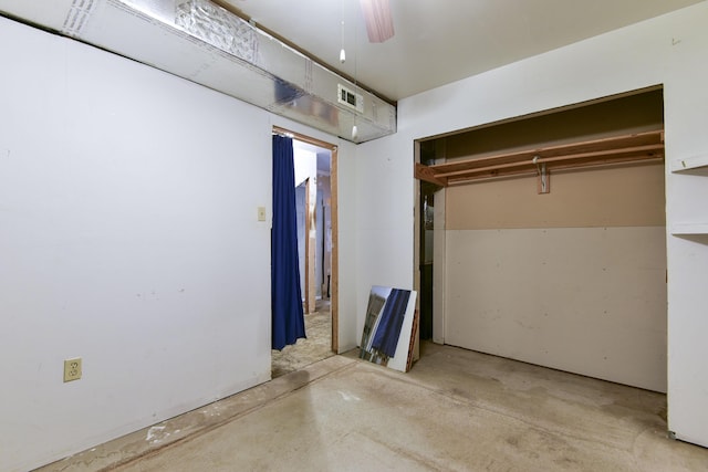 unfurnished bedroom with ceiling fan and a closet