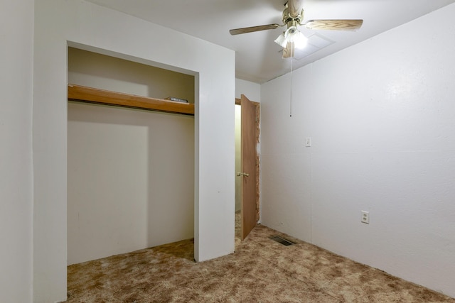 unfurnished bedroom featuring ceiling fan, light colored carpet, and a closet