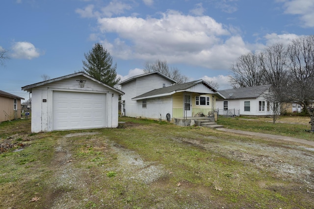 single story home featuring a garage, an outdoor structure, and a front yard