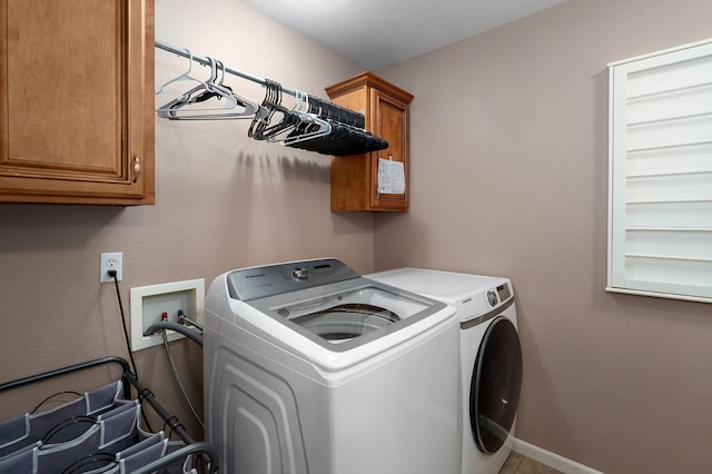 washroom featuring cabinets and washing machine and clothes dryer