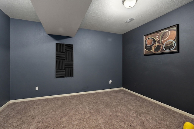 spare room featuring carpet and a textured ceiling