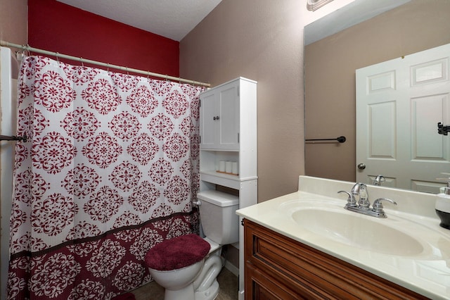 bathroom featuring a textured ceiling, vanity, and toilet