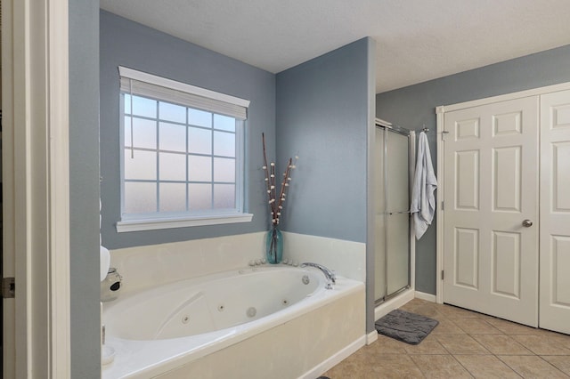 bathroom featuring separate shower and tub, tile patterned flooring, and a textured ceiling