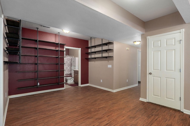 basement with a textured ceiling and dark wood-type flooring