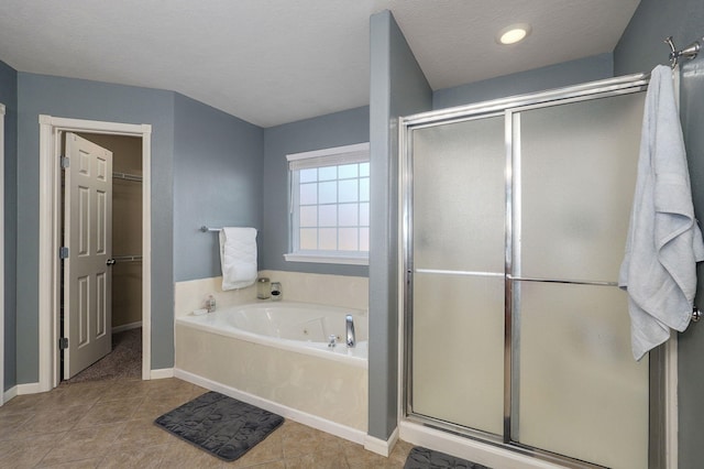 bathroom with tile patterned flooring, shower with separate bathtub, and a textured ceiling