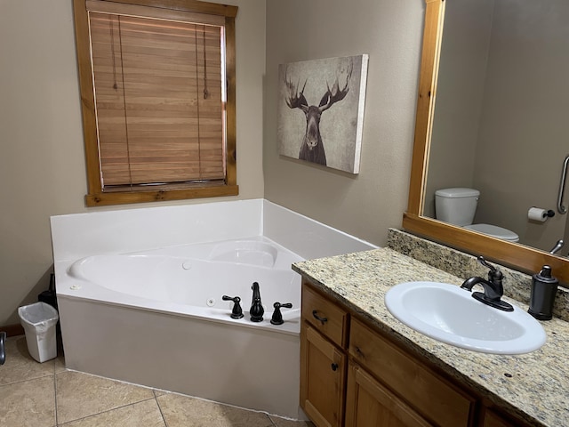 bathroom featuring tile patterned floors, a bathtub, vanity, and toilet